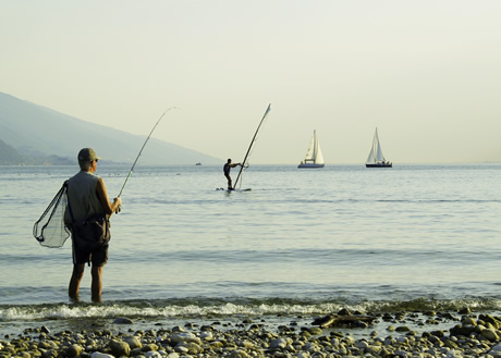 Windsurfeurs et pêcheurs sur le lac de Garda photo